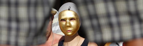Justin Bieber wears a gold mask