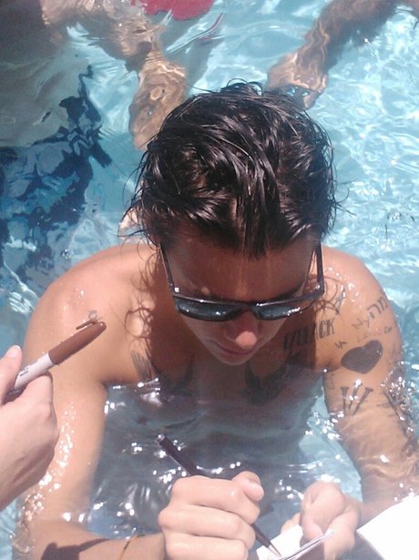 Harry Styles signs autographs in the pool